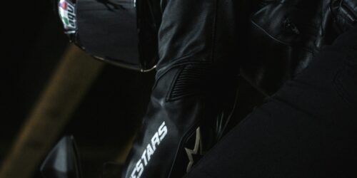 Een motorcrosser met Alpinestars Tech 10 laarzen, handschoenen en helm racet over een stoffig parcours.