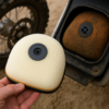 Nieuwe luchtfilter van een crossmotor in close-up, met zichtbaar vuil en zand op de oude filter op de achtergrond