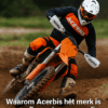 Een motorcrosser in volledige Acerbis outfit rijdt door een modderige bocht, met handkappen en bodyprotector zichtbaar tijdens actie op het circuit