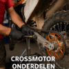 Monteur vervangt onderdelen van een crossmotor in de werkplaats – focus op technische details