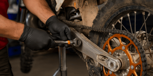 Monteur vervangt onderdelen van een crossmotor in de werkplaats – focus op technische details