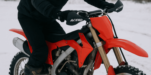 Motocrosser start zijn crossmotor op een besneeuwde ondergrond in winterse omstandigheden